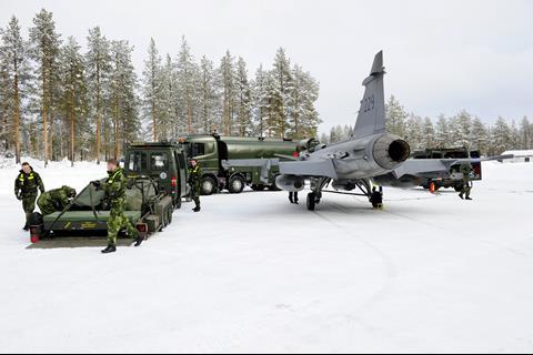Saab Gripen being inspected by mobile maintenance crew on snowy flightline c Royal Swedish Air Force